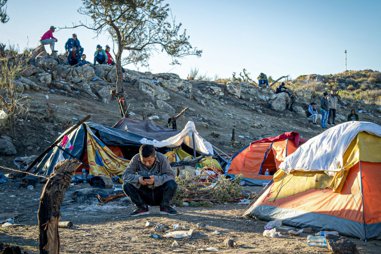 A Chinese migrant sits in front of his tent near the U.S. - Mexico border.
