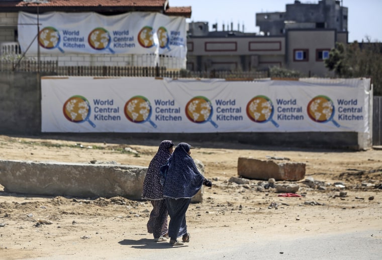 Palestinians walking in front of the closed headquarters of the World Central Kitchen on April 3, 2024,  west of Nuseirat, central Gaza.