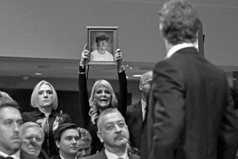 Jennie DeSerio with Mason's picture as Meta CEO Mark Zuckerberg speaks to victims and their family members as he testifies at a Senate Judiciary Committee hearing, "Big Tech and the Online Child Sexual Exploitation Crisis," in Washington on Jan 31. 