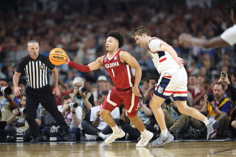 Mark Sears #1 of the Alabama Crimson Tide dribbles the ball while being guarded by Cam Spencer #12 of the Connecticut Huskies in the first half in the NCAA Final Four game at State Farm Stadium on April 6, 2024 in Glendale, Ariz.