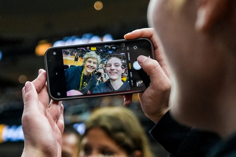 Iowa head coach Lisa Bluder poses for a selfie with a fan