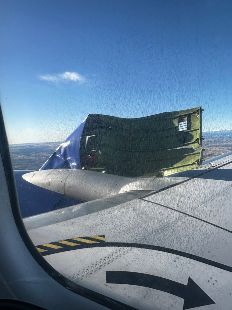 The engine cowling hanging from the wing of a Southwest Airlines flight