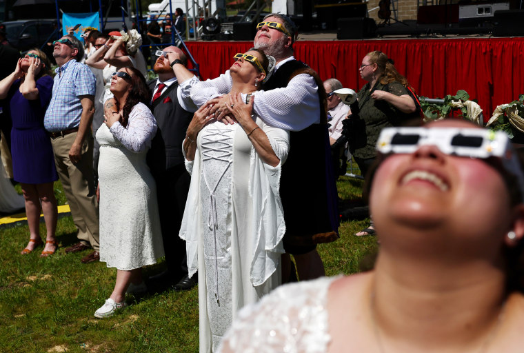 Image: Couples look at the eclipse during a mass wedding ceremony in Russellville, Ark.