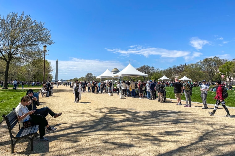 Residents from across the DMV and beyond were already staking spots on the grass to watch the solar eclipse on the National Mall on April 8, 2024.