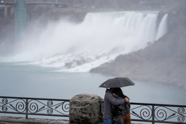 People gather under overcast skies ahead of a total solar eclipse in Niagara Falls, Ontario, Monday, April 8, 2024.