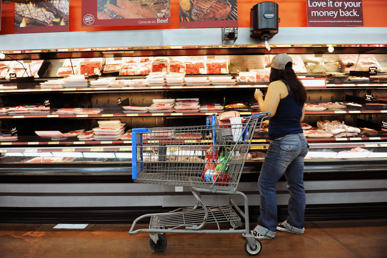 A customer looks at meat inside a Walmart.