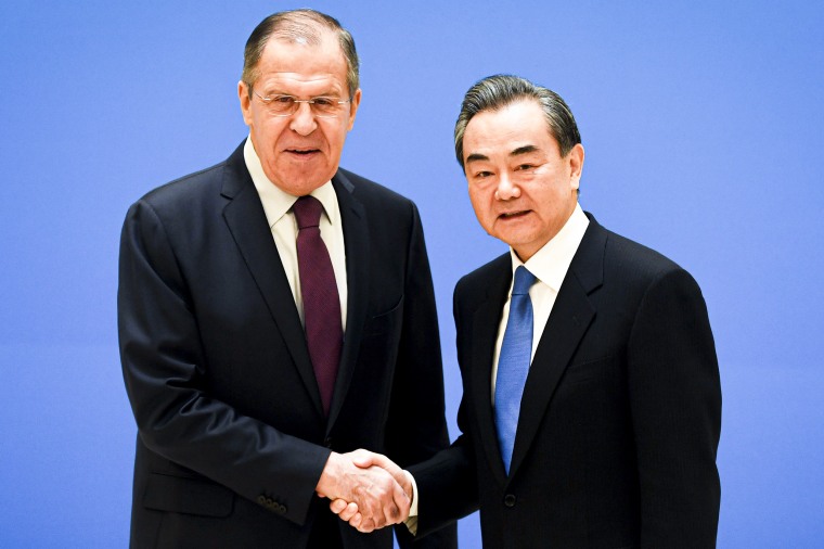 Russian Foreign Minister Sergei Lavrov, left, shakes hands with Chinese State Councilor and Foreign Minister Wang Yi.