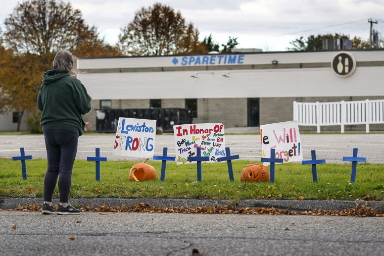 A woman visits a makeshift memorial outside Just-In-Time Recreation, the site of one of this week's mass shootings, Saturday, Oct. 28, 2023, in Lewiston, Maine.