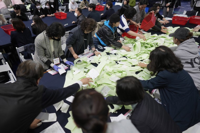 National Election Commission officials sort out ballots for the parliamentary election in Seoul, South Korea
