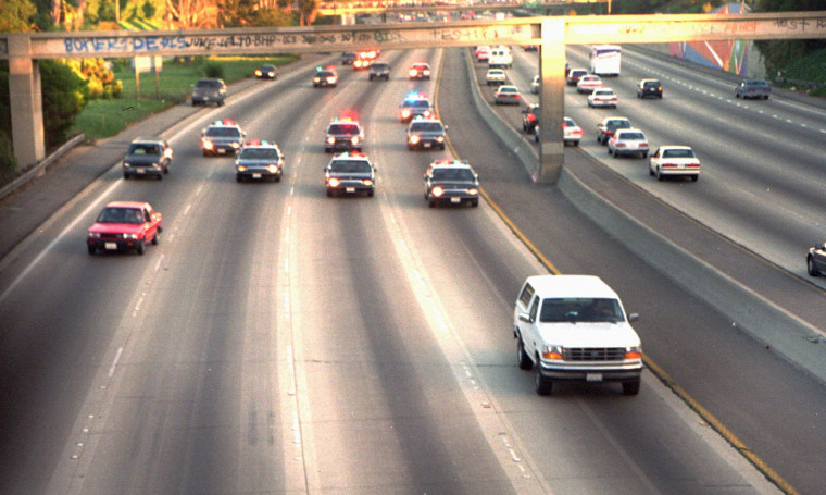 A white Ford Bronco, driven by Al Cowlings and carrying O.J. Simpson, is trailed by police cars as it travels on a southern California freeway in Los Angeles on June 17, 1994.