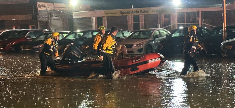 Swift-water rescue paramedics rescue a driver trapped in a vehicle in Pittsburgh on Friday.