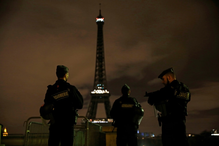 Armed police stand guard overlooking the Eiffel Tower