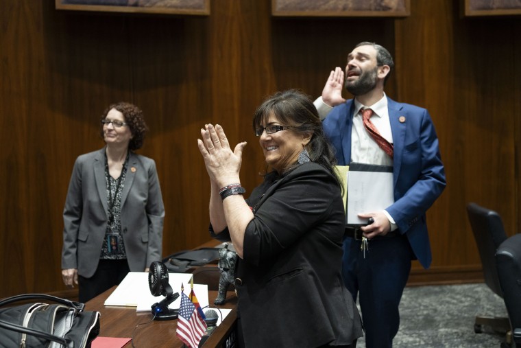Barbara Parker, center, and Alex Kolodin celebrate their session being called to recess during a legislative session at the Arizona House of Representatives in Phoenix