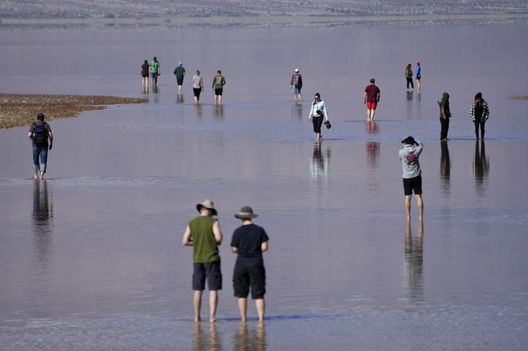 People wade through water at Badwater Basin on Feb. 22, 2024, in Death Valley National Park, Calif. 