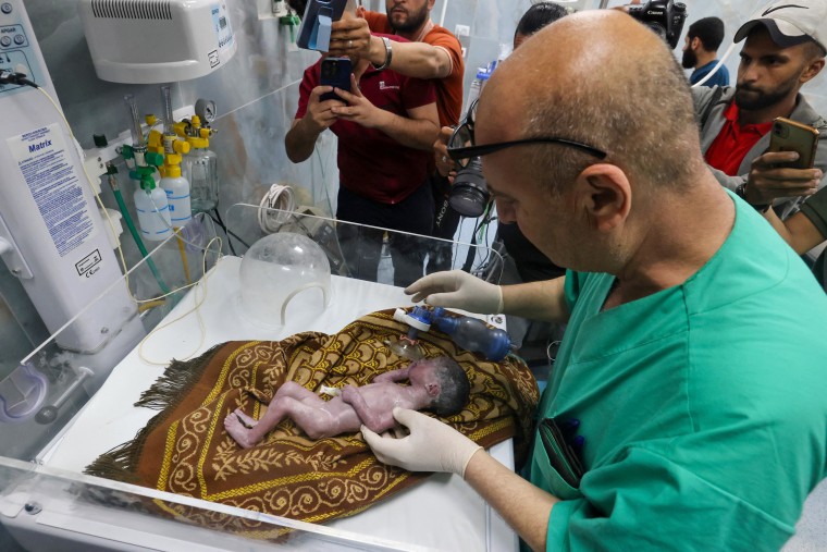 2024 年 4 月 20 日，加沙地带南部拉法的科威特医院，一名巴勒斯坦医生正在照顾 Sabreen Jouda，她的母亲在以色列袭击中丧生，她因此而早产。