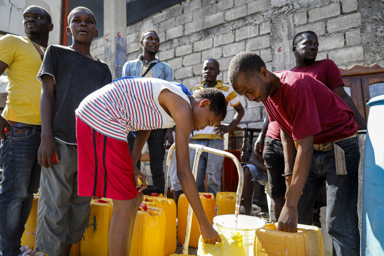 Residents fill their containers with potable water