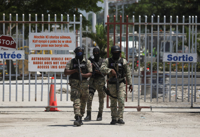Haitian police officers walk out of the international airport in Port-au-Prince, Haiti