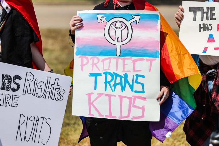 A protester's sign reads, ''protect trans kids'' at a demonstration