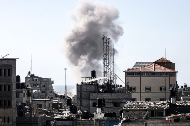 Smoke rises above buildings during Israeli bombardment.