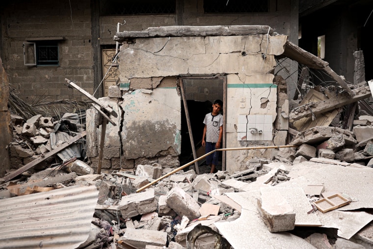A Palestinian child stands amid the debris of a house destroyed by overnight Israeli bombardment.