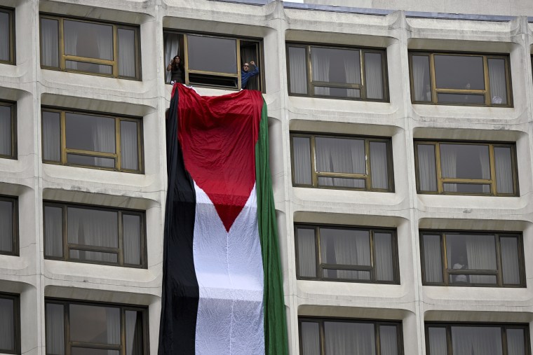 A Palestinian flag divides a window at the Washington Hilton during a protest over the Israel-Hamas war, at a White House Correspondents' Association dinner on Saturday.