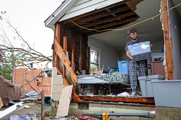Sean Thomas Sledd salvages items from his room after it was hit by a tornado