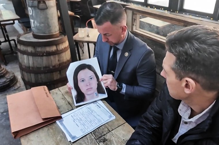 NYPD Detective Ryan Glas holds a digital composite photograph of Patricia Kathleen McGlone.