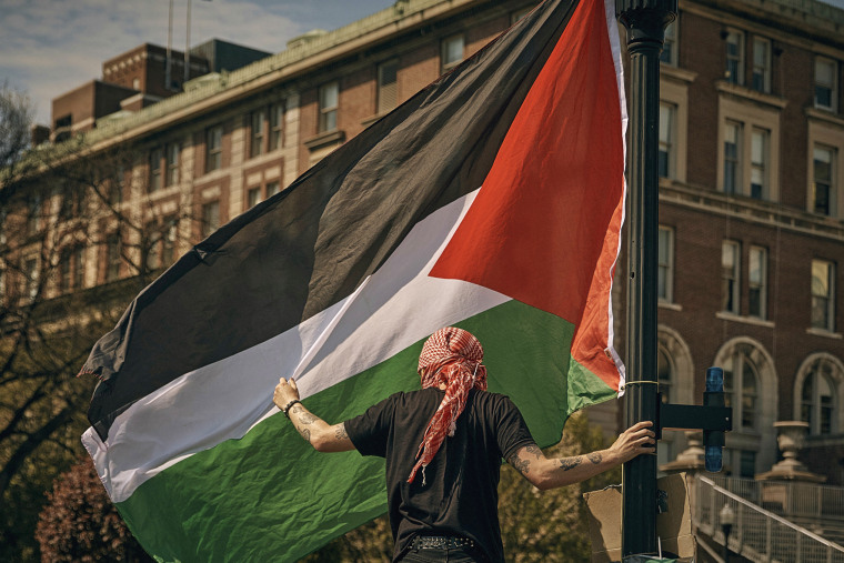 A protester places a Palestinian flag at a pro-Palestinian encampment at Columbia University, in New York, Sunday, April 28, 2024.