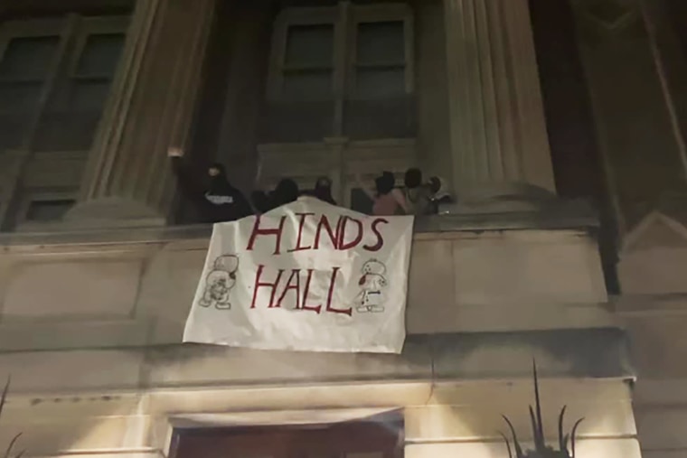 Protesters raise a banner reading "Hinds Hall" from the Hamilton Hall building on Columbia University campus in New York City on April 30, 2024.
