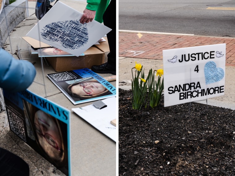 People set up signs during an April 7 protest near Stoughton Town Hall calling for further investigation into Sandra Birchmore’s death.