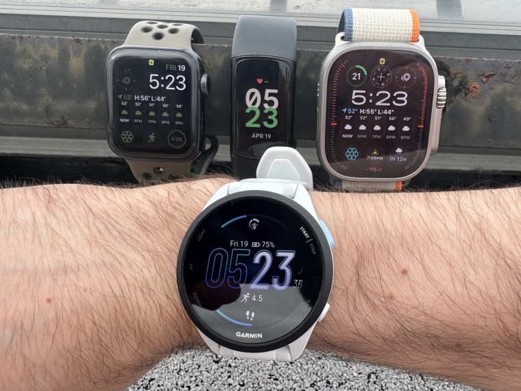 Close up shot of the Forerunner 165 (front) alongside the Apple Watch SE, Fitbit Charge 6 and Apple Watch Ultra 2 (back).