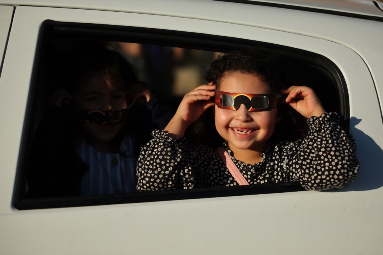 Una niña en Mazatlán, México, prueba las gafas especiales para protegerse del eclipse total.