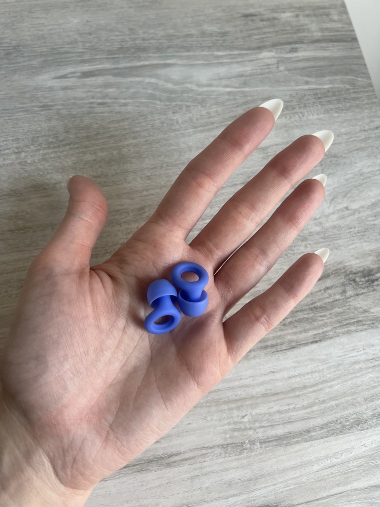Person holding a pair of Loop Quiet earplugs in the palm of their hand.