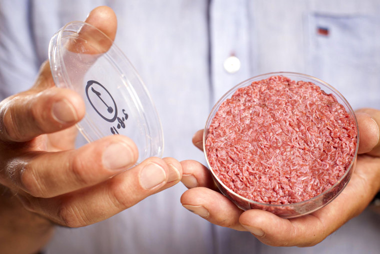 A person holds a lab-grown meat package.