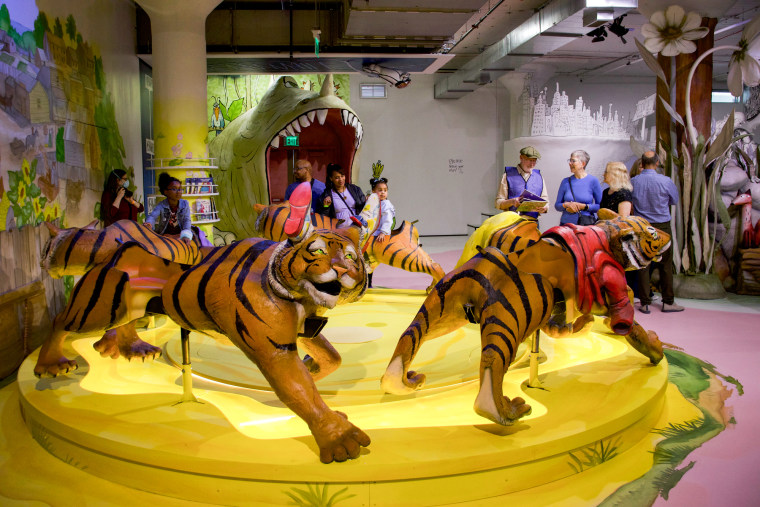 Children play on a carousel with tiger characters as the seats