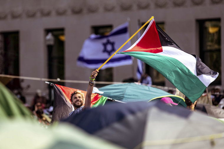 A student demonstrator waves a Palestinian flag at the "Gaza Solidarity Encampment" at Columbia University.