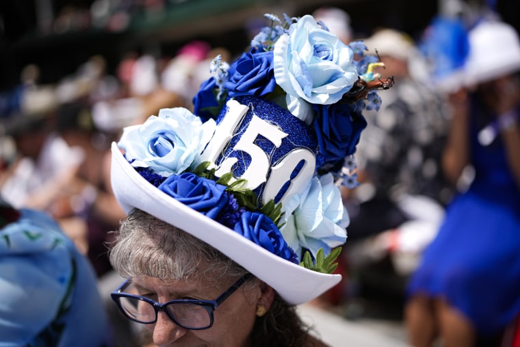 A race fan with a huge hat commemorating the 150th year.