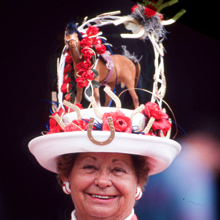A fan wears a derby hat with a horse.