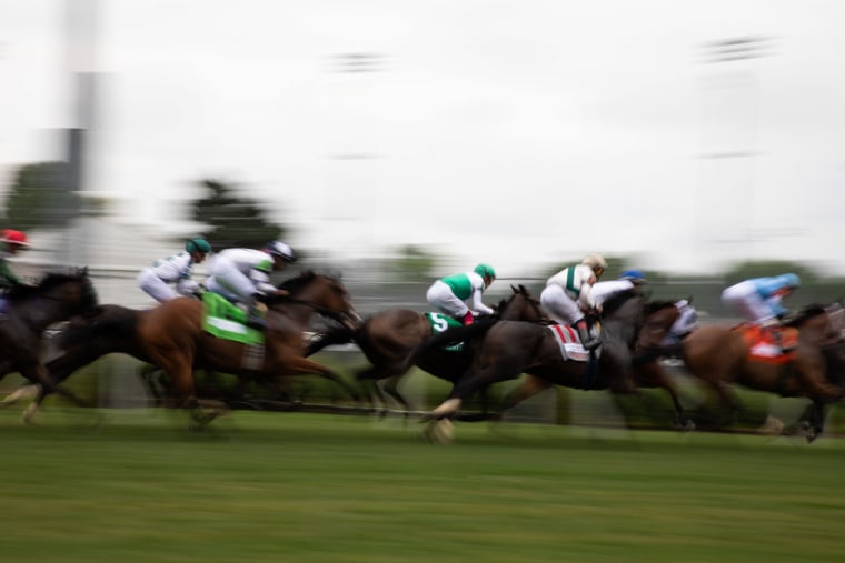 Horses and jockeys race at Churchill Downs.