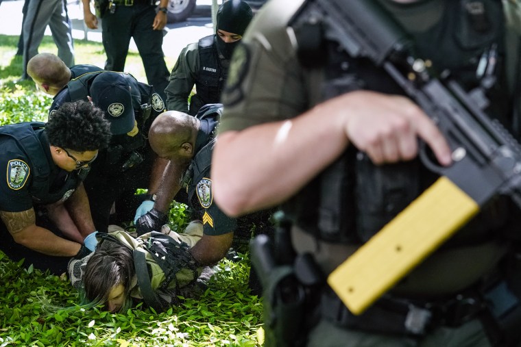 Police officers detain a demonstrator during a pro-Palestinian protest at Emory University