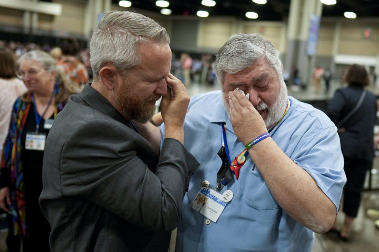 Rev. Andy Oliver, left, and David Meredith wipe away tears after an approval vote at the United Methodist Church General Conference.