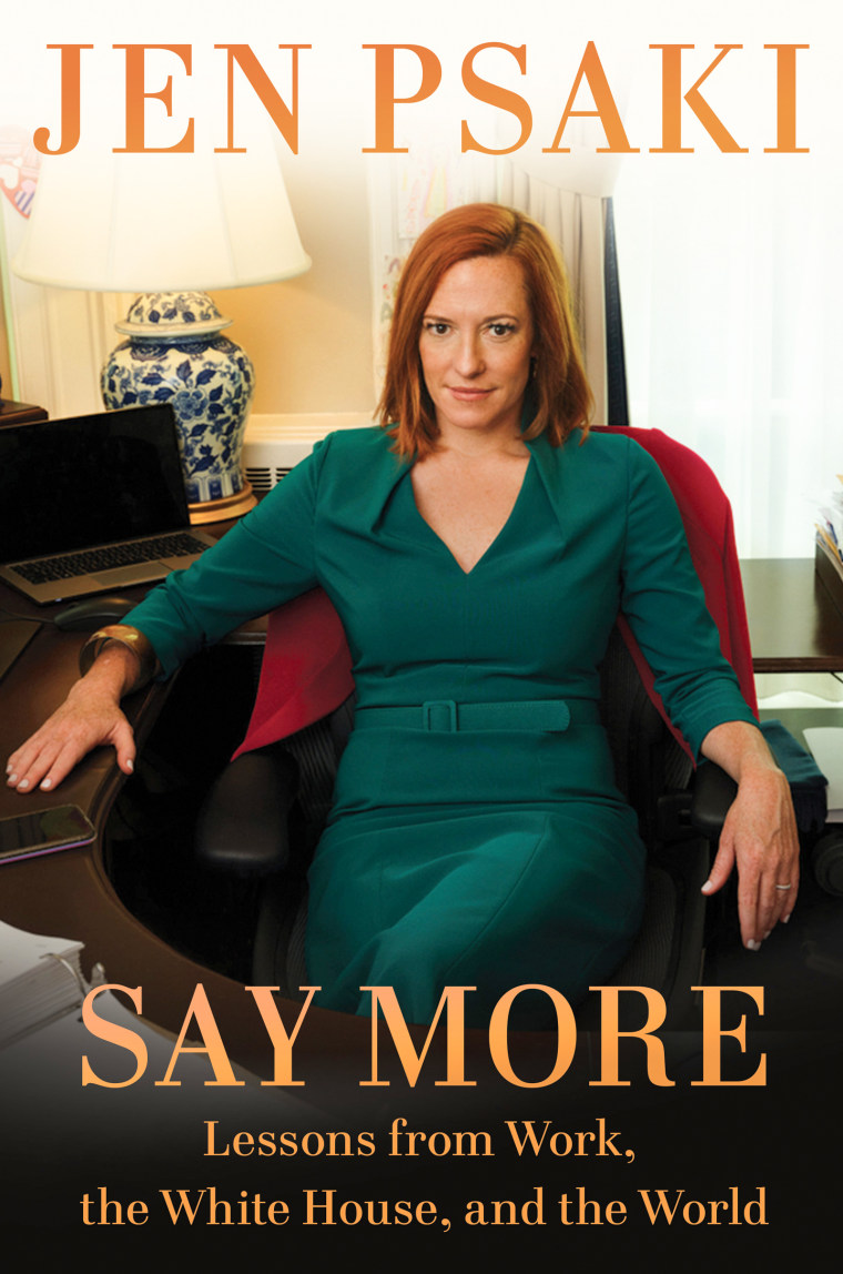 On the cover of her book, Jen Psaki sits at a computer desk in a green dress