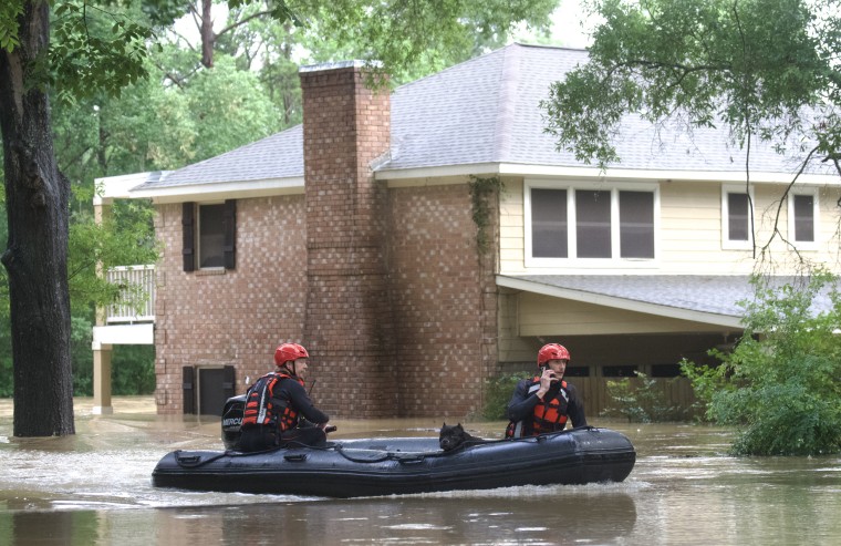 Emergency workers with Caney Creek Fire and Rescue boat out dogs from a flood portion of River Plantation Drive in River Plantation, Texas