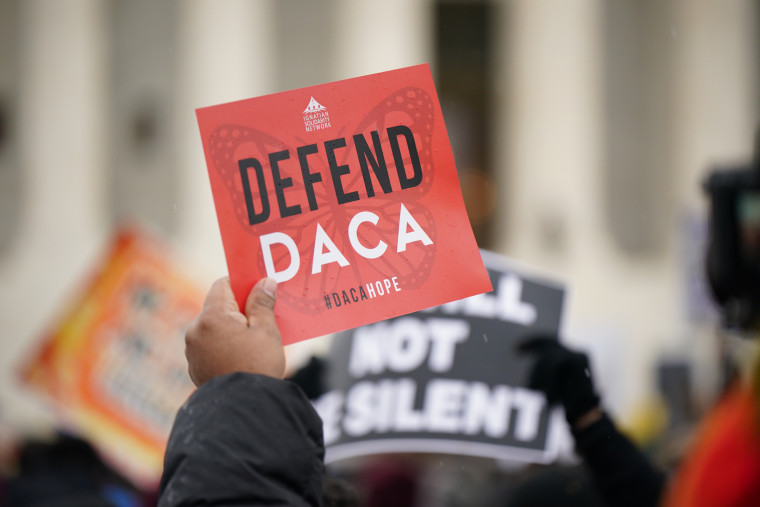 An activist holds a "Defend Daca" sign in front of the Supreme Court