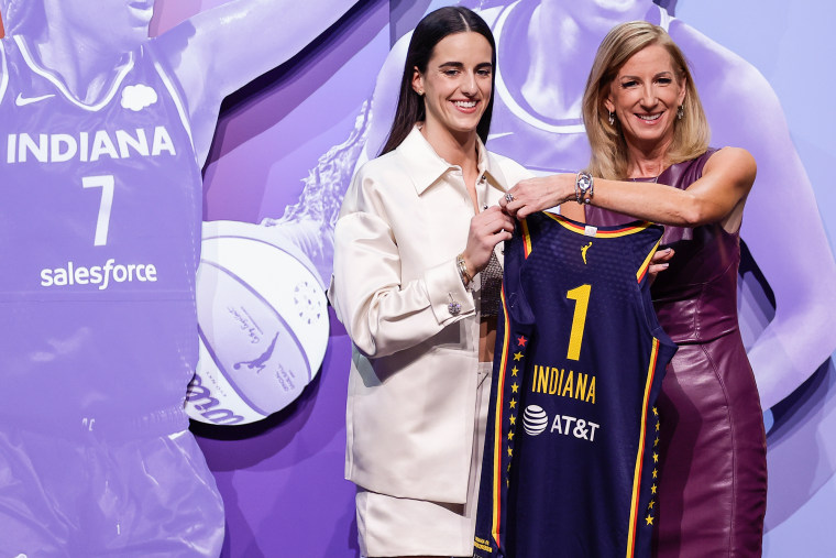 Caitlin Clark, left, holds an Indiana Fever jersey and poses for a photo with Cathy Engelbert