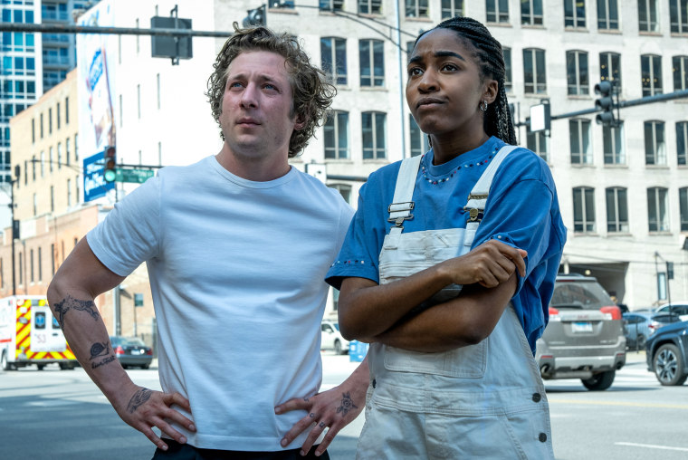 Jeremy Allen White and Ayo Edebiri stand next to each other outside in the city of Chicago