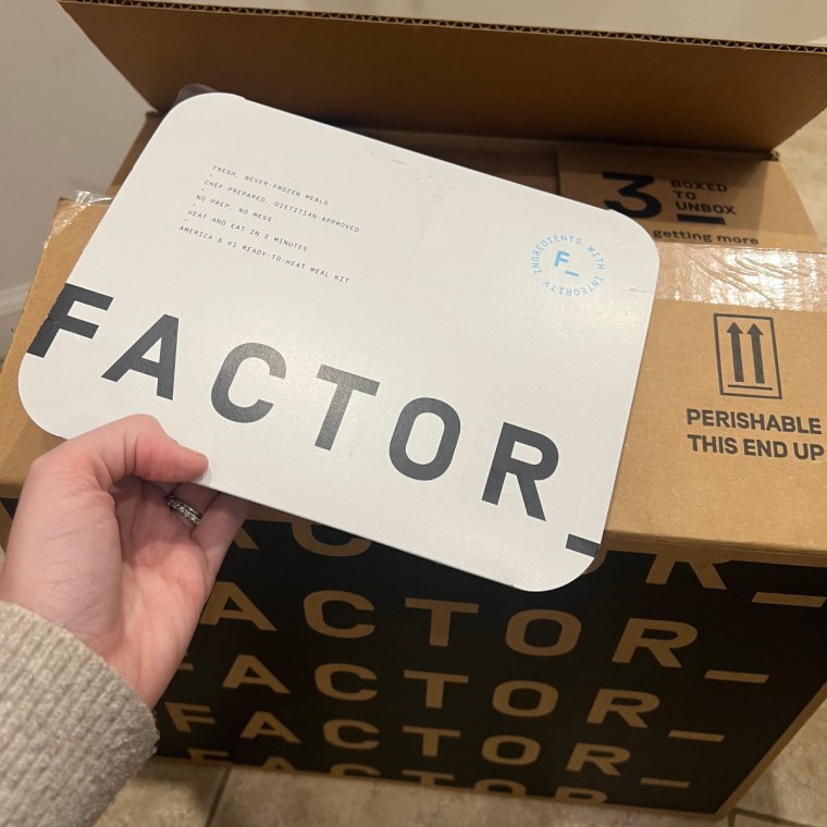 Unopened Factor meal held in front of Factor delivery box