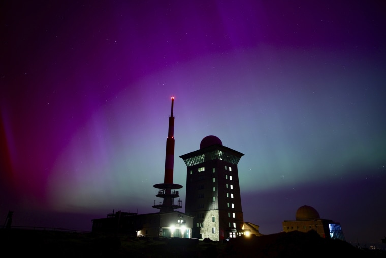 Northern lights appear in the night sky above the Brocken