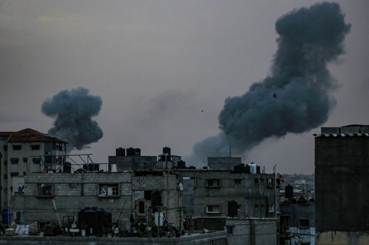 Smoke rises above damaged buildings