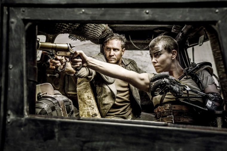 Charlize Theron and Tom Hardy pointing guns in a scene from the movie